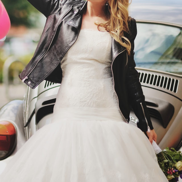 bride wearing leather jacket in front of a car