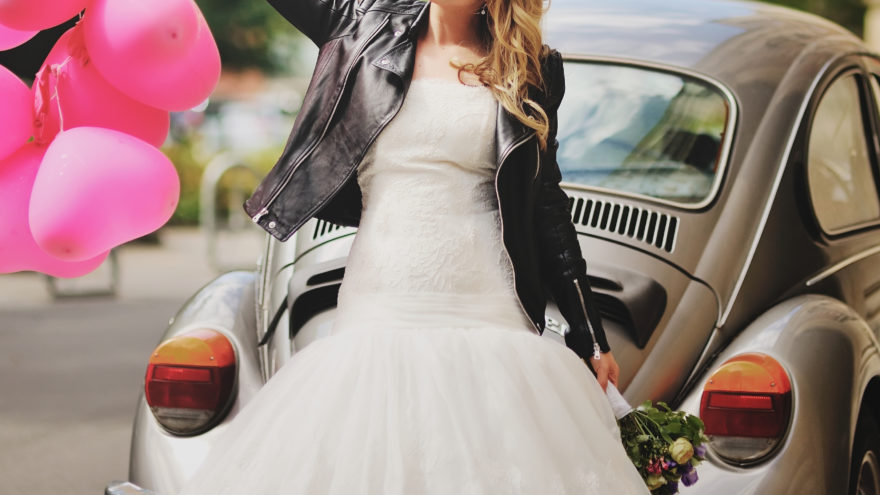 bride wearing leather jacket in front of a car